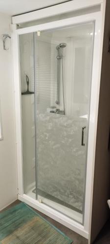La salle de bains est pourvue d'un lavabo et d'une porte de douche en verre. dans l'établissement Argeles Mobil'holidays del mar camping 222, à Argelès-sur-Mer