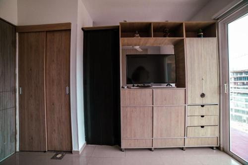 a living room with a television and wooden cabinets at Apartamento Terrazas Tayrona in Gaira