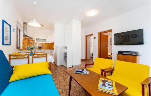 een woonkamer met een blauwe bank en gele stoelen bij Nice Home In Razanac With Wifi in Ražanac