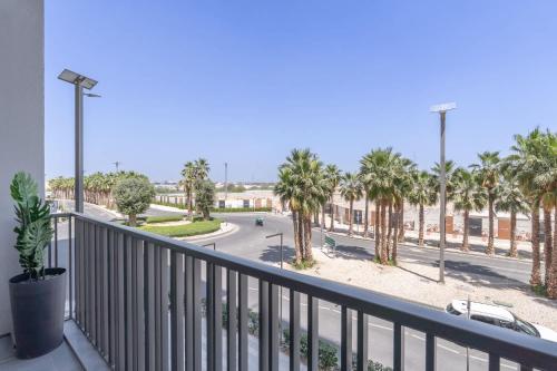 a balcony with a view of a street with palm trees at Free housekeeping visits during your stay - StayShort - Modern and Stunning Studio in MAG 910 MBR City in Dubai