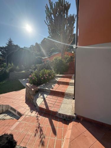 a shadow of a person walking on a brick patio at Agriturismo Un Mare di Fiori in Ventimiglia