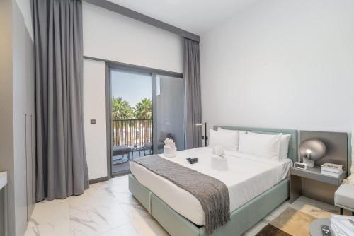 a bedroom with a large bed and a balcony at Free housekeeping visits during your stay - StayShort - Modern and Stunning Studio in MAG 910 MBR City in Dubai