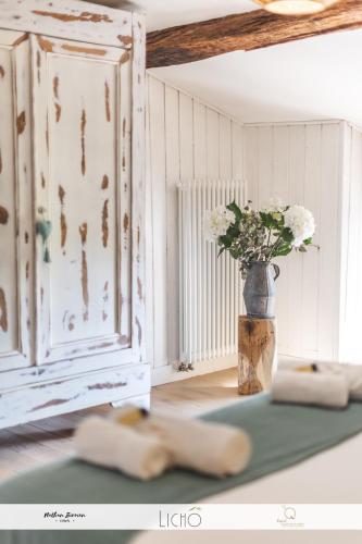 un vase de fleurs dans une chambre avec fenêtre dans l'établissement Domaine de Lorette, à Fossés-et-Baleyssac