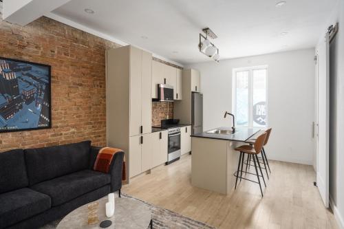 a living room with a couch and a kitchen at MTL Central Stay Apartments in Montréal
