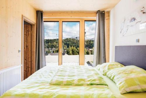 a bedroom with a bed and a large window at FeWo Nocky- SAUNA- Wandern- Berge- Auszeit- Liftnähe in Turracher Hohe