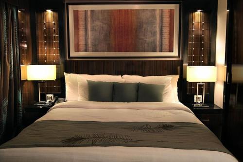 a bedroom with a large bed with two lamps at King of The Vally Nile Cruise Aswan To Luxor 3 Night And visit the Nubian village in Aswan