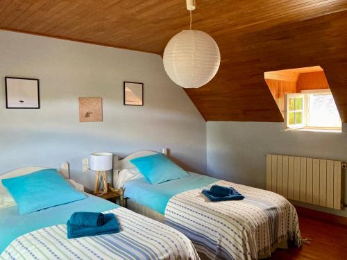 une chambre avec deux lits avec des serviettes dessus dans l'établissement Benniel bras maison de vacances à 5 minutes des plages, à Plomodiern