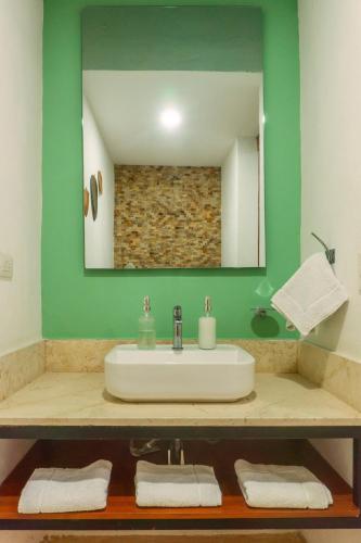 a bathroom with a sink and a mirror at Casa de las Puertas in Mérida
