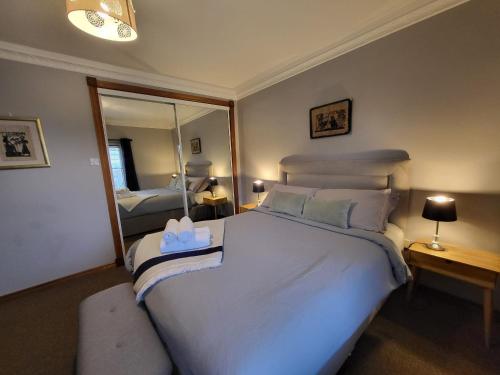 a bedroom with a large white bed and a mirror at Red Brick House Rosses Point in Sligo