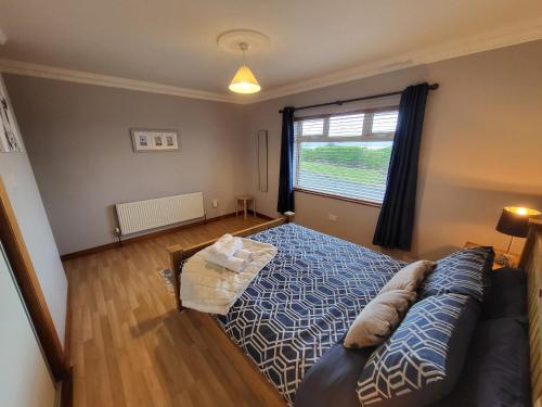a bedroom with a large bed and a window at Red Brick House Rosses Point in Sligo