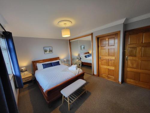 a bedroom with a bed and a chair and a door at Red Brick House Rosses Point in Sligo