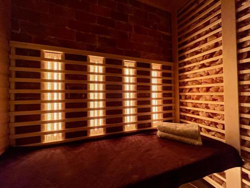 a room with a bench with a brick wall at JohnGold Apartment Debrecen in Debrecen