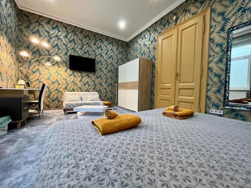 a bedroom with a large bed with yellow pillows on it at JohnGold Apartment Debrecen in Debrecen