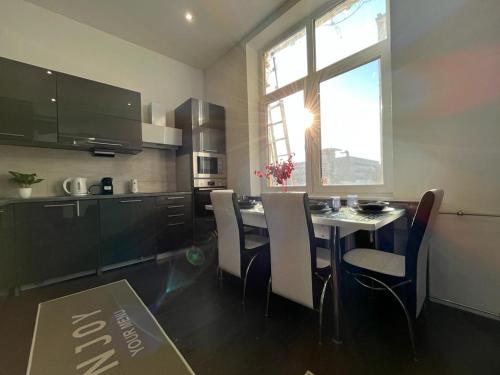 a kitchen with a table and chairs in a room at JohnGold Apartment Debrecen in Debrecen