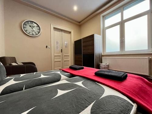 a bedroom with a large bed and a clock on the wall at JohnGold Apartment Debrecen in Debrecen