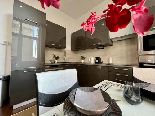 a kitchen with red flowers hanging from the ceiling at JohnGold Apartment Debrecen in Debrecen