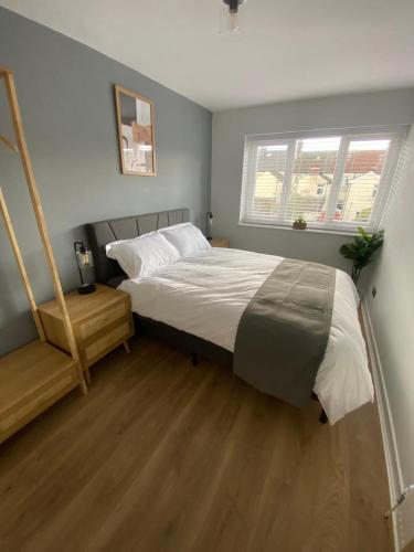 a bedroom with a large bed and a window at 3 Bedroom House in Cardiff in Cardiff