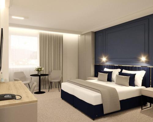 a bedroom with a large bed with a blue headboard at Moris Beach Hotel in Gdańsk