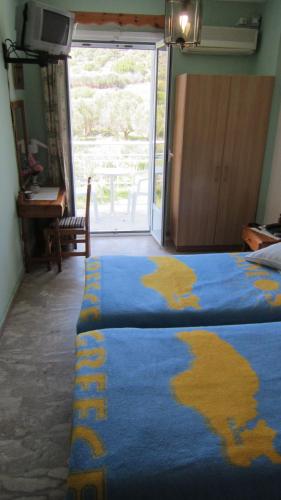 a bedroom with a blue blanket with a map on it at Sandalis Hotel in Pythagoreio