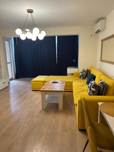a living room with a yellow couch and a table at Sandanski Apartments Top Center in Sandanski