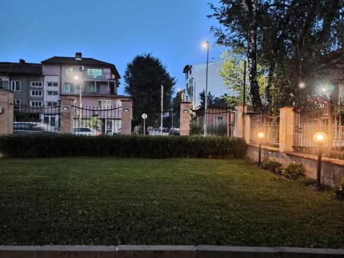 un parque de noche con una valla y un edificio en Statevi Guest Apartment 1, en Velingrad