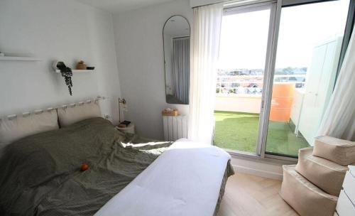 une chambre avec un lit et une grande fenêtre dans l'établissement Résidence Les Océanes - maeva Home - Studio duplex vue mer 4 personnes - Confort MAE-9231, à Pornichet