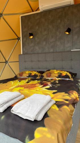 a bedroom with a bed with a painting on it at Saules sēta in Tīnūži