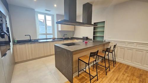 une cuisine avec un comptoir avec des chaises et un évier dans l'établissement Le Vercingétorix 2 #Confort, à Aubière