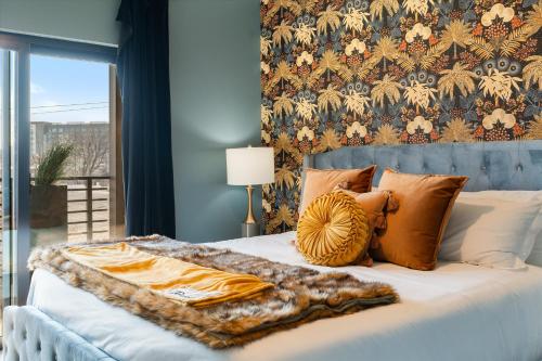 Una cama con una manta y almohadas encima en Hyve, en Nashville