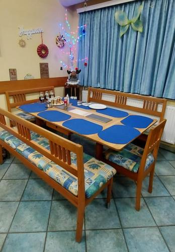 a dining room table with two chairs and a blue table at Hotel Sananda-Farm in Vienna