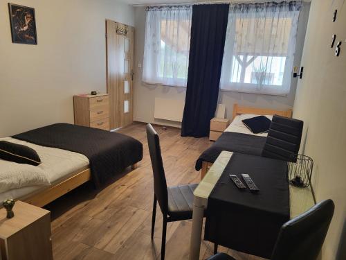 a bedroom with two beds and a table and a dining room at Agroturystyka Nad strumykiem in Leśna
