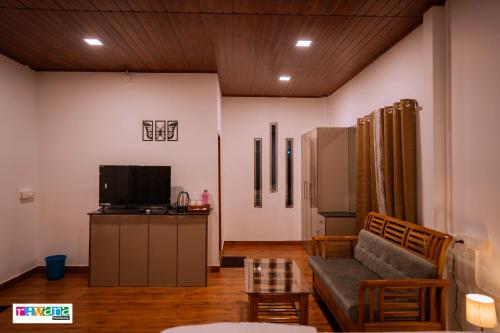 a living room with a couch and a tv at Rivana Homestay in Kushālnagar