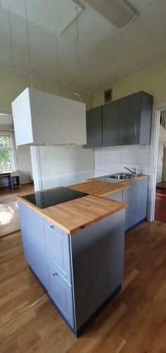 a kitchen with white cabinets and a wooden counter top at Villa Central in Asker