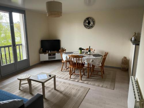 un salon avec une table, des chaises et une télévision dans l'établissement L étoile Solange, à Grandcamp-Maisy