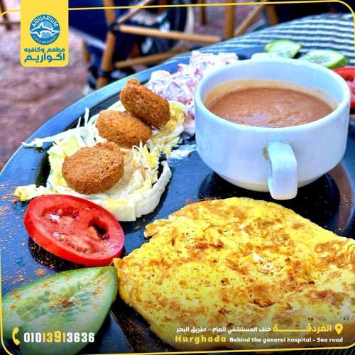 a blue plate with food and a cup of soup at Sea Life Apartments-hotel in Hurghada