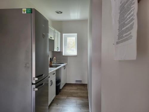 a kitchen with a refrigerator and a sink at Agroturystyka Nad strumykiem in Leśna