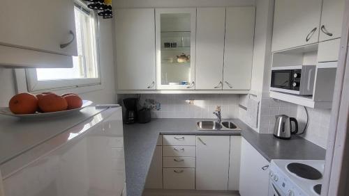 una cucina con armadi bianchi e un cesto di frutta di Direct train to Helsinki and airport, near shopping center a Vantaa