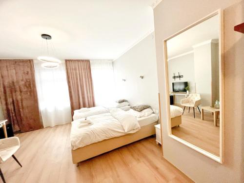 ein Schlafzimmer mit einem Bett und einem großen Spiegel in der Unterkunft Apartamenty Castello Kamilla in Kluczbork