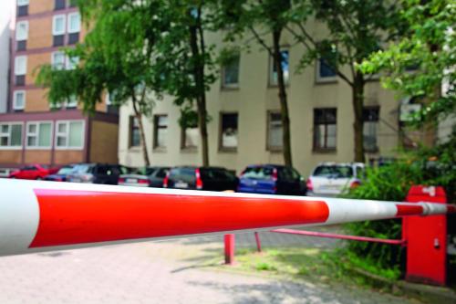 a red and white barrier in front of a parking lot at Auto-Parkhotel in Hamburg