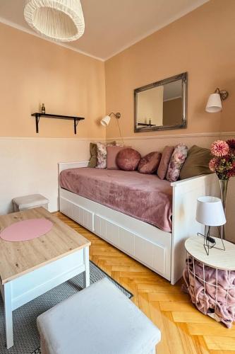 a bedroom with a bed with a mirror and a table at Middle of the city apartman 2 in Pécs