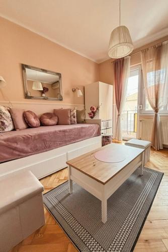 a living room with a bed and a coffee table at Middle of the city apartman 2 in Pécs