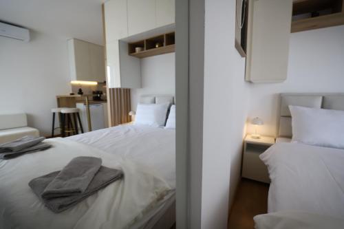 a bedroom with two white beds with towels on it at Apartman Aleksandra Vrnjacka Banja in Vrnjci