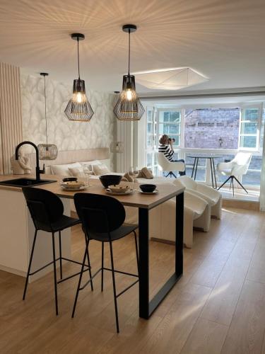 a kitchen and living room with a table and chairs at Abrazo a la Catedral by Unique Rooms in Burgos