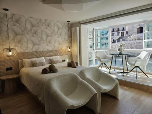 a bedroom with a bed and a table and chairs at Abrazo a la Catedral by Unique Rooms in Burgos