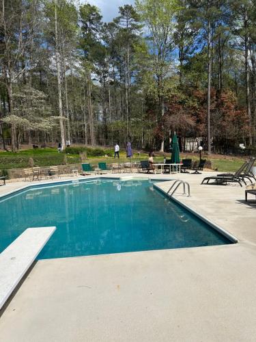 een zwembad in een park met tafels en stoelen bij Walker Resort in Fayetteville