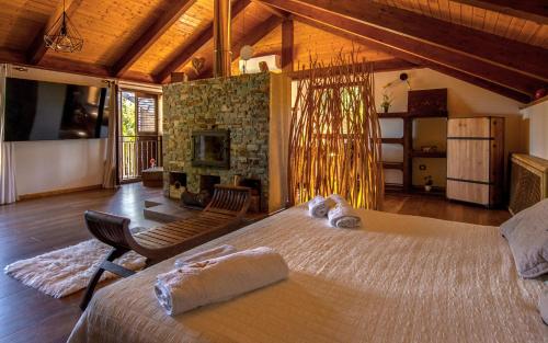 El ÁlamoにあるVilla Oasis Madridのベッドルーム1室(大型ベッド1台、椅子2脚、暖炉付)