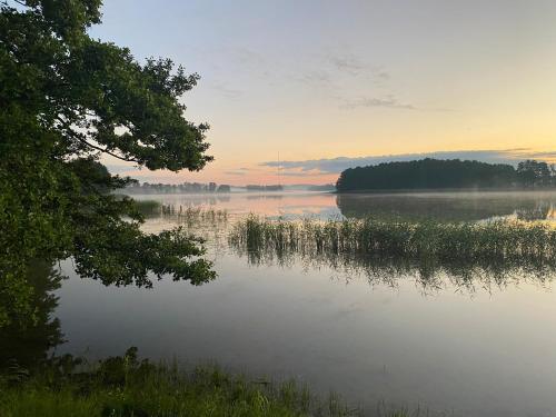 a view of a lake at sunset at Dom nad Buwełnem in Marcinowa Wola