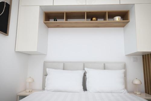 a bedroom with a white bed with white pillows at Apartman Aleksandra Vrnjacka Banja in Vrnjci