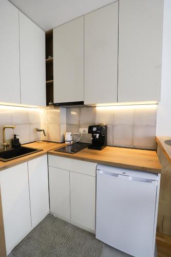 a white kitchen with white cabinets and a sink at Apartman Aleksandra Vrnjacka Banja in Vrnjci