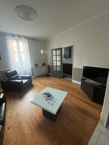 un salon avec un canapé et une table basse dans l'établissement Maison 5mn du centre ville du Mans à pied, au Mans